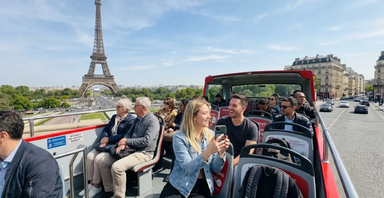 Group of tourists on the upper deck of a red open-top double-decker bus pointing towards the Eiffel Tower in the distance